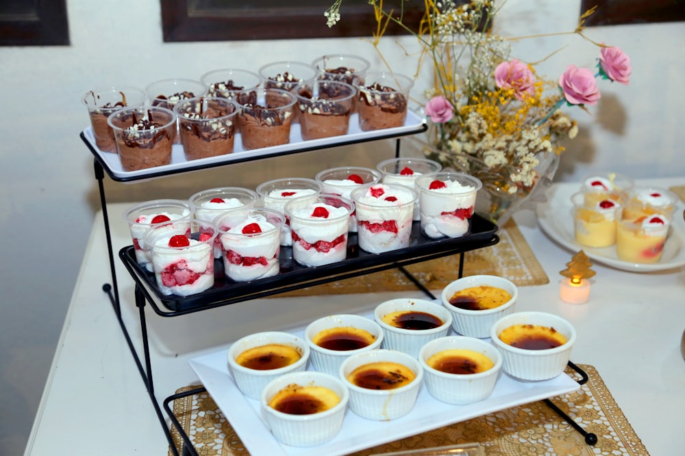 a table topped with desserts and dessert cups