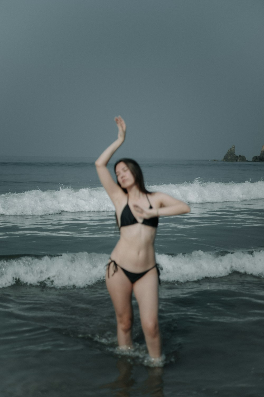 a woman in a bikini standing in the ocean
