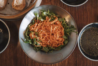 Elegant plating of a steaming bowl of Asian-inspired noodles with chopsticks.