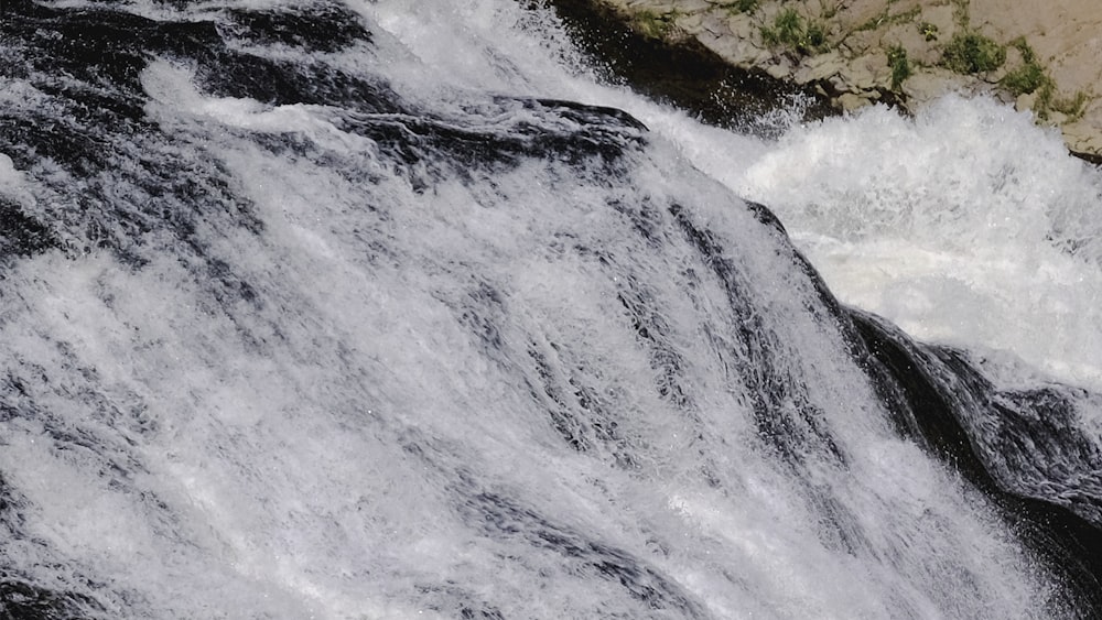 a man riding a surfboard on top of a waterfall