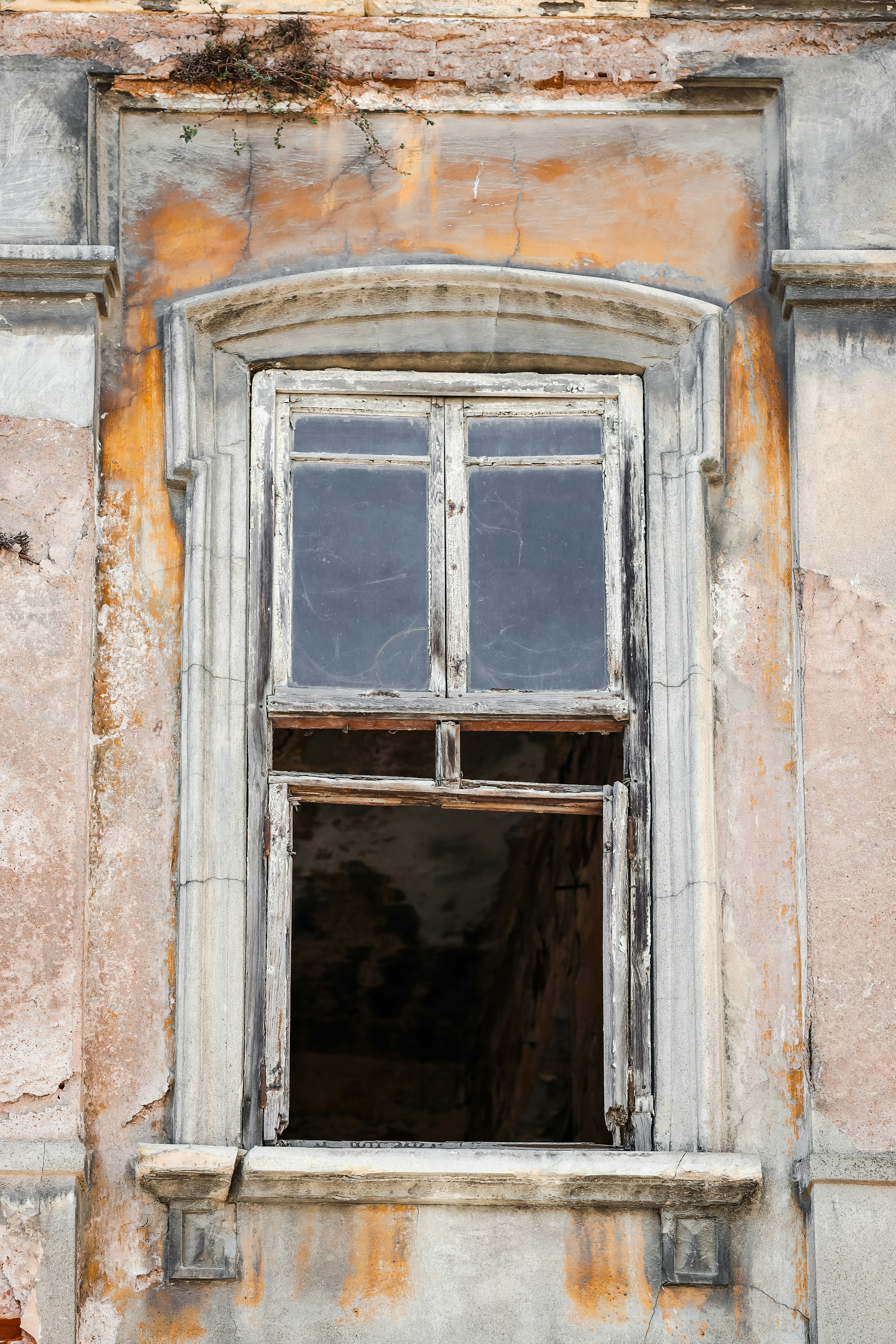 an old building with a broken window and peeling paint
