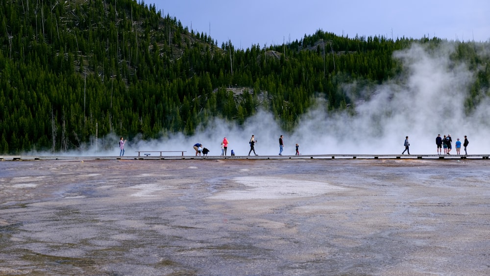 a group of people standing in front of a geyser