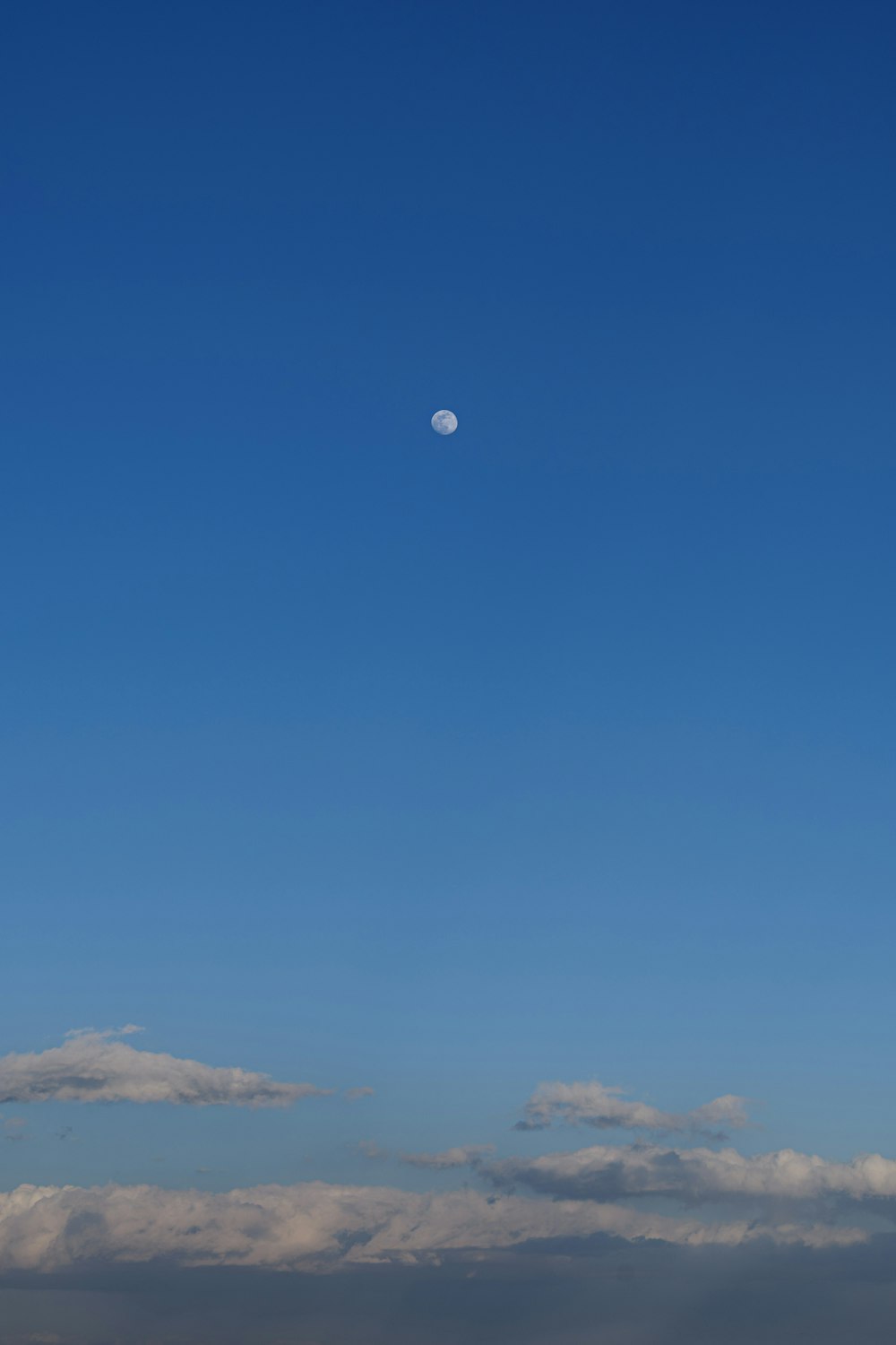 un aereo che vola nel cielo con una luna sullo sfondo