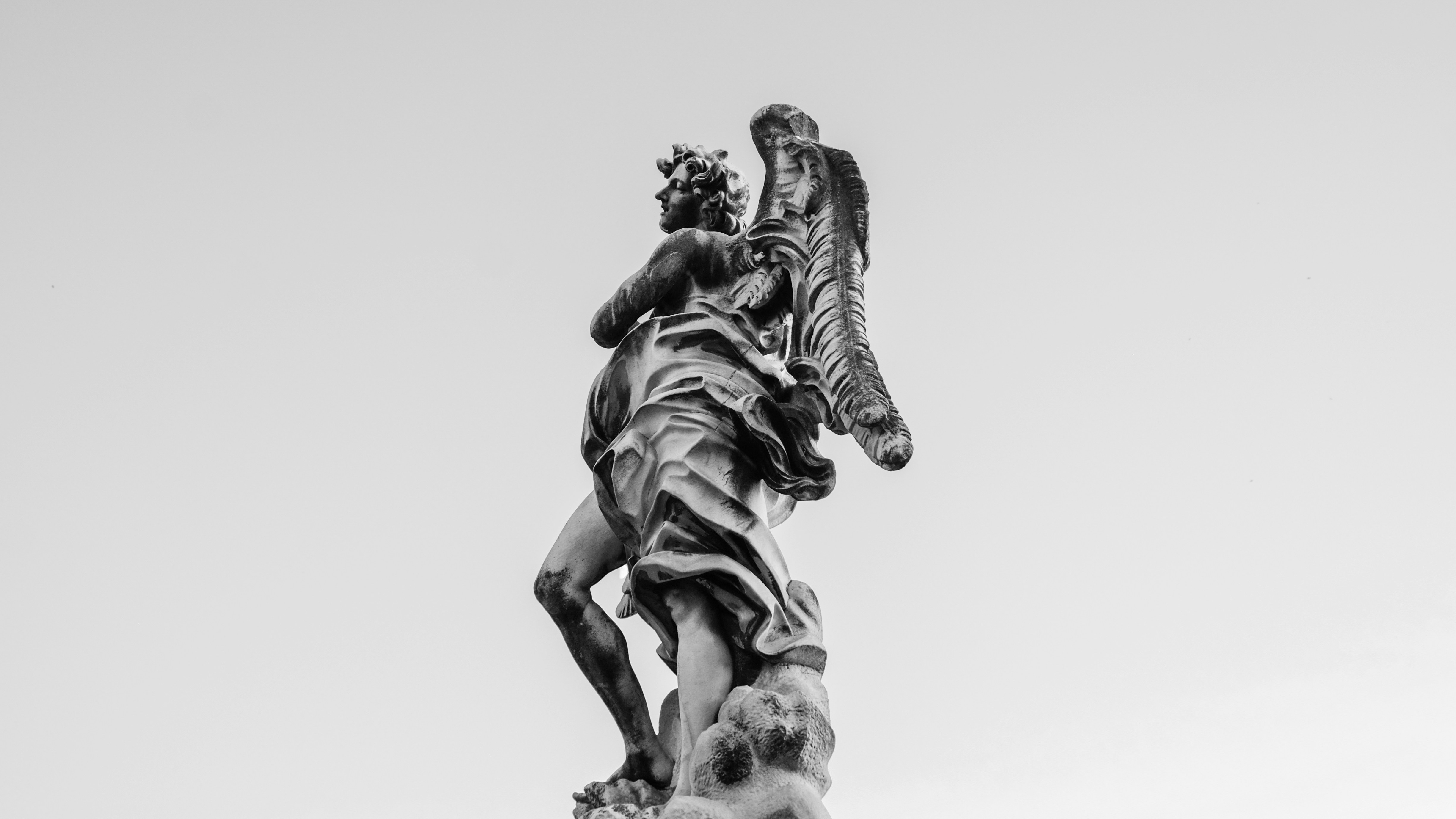 a black and white photo of a statue of an angel
