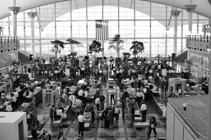 An aviation security officer carefully inspecting passenger documents at a checkpoint.