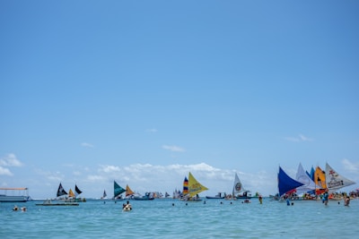 A group of friends sailing on a bright sunny day with clear blue skies.