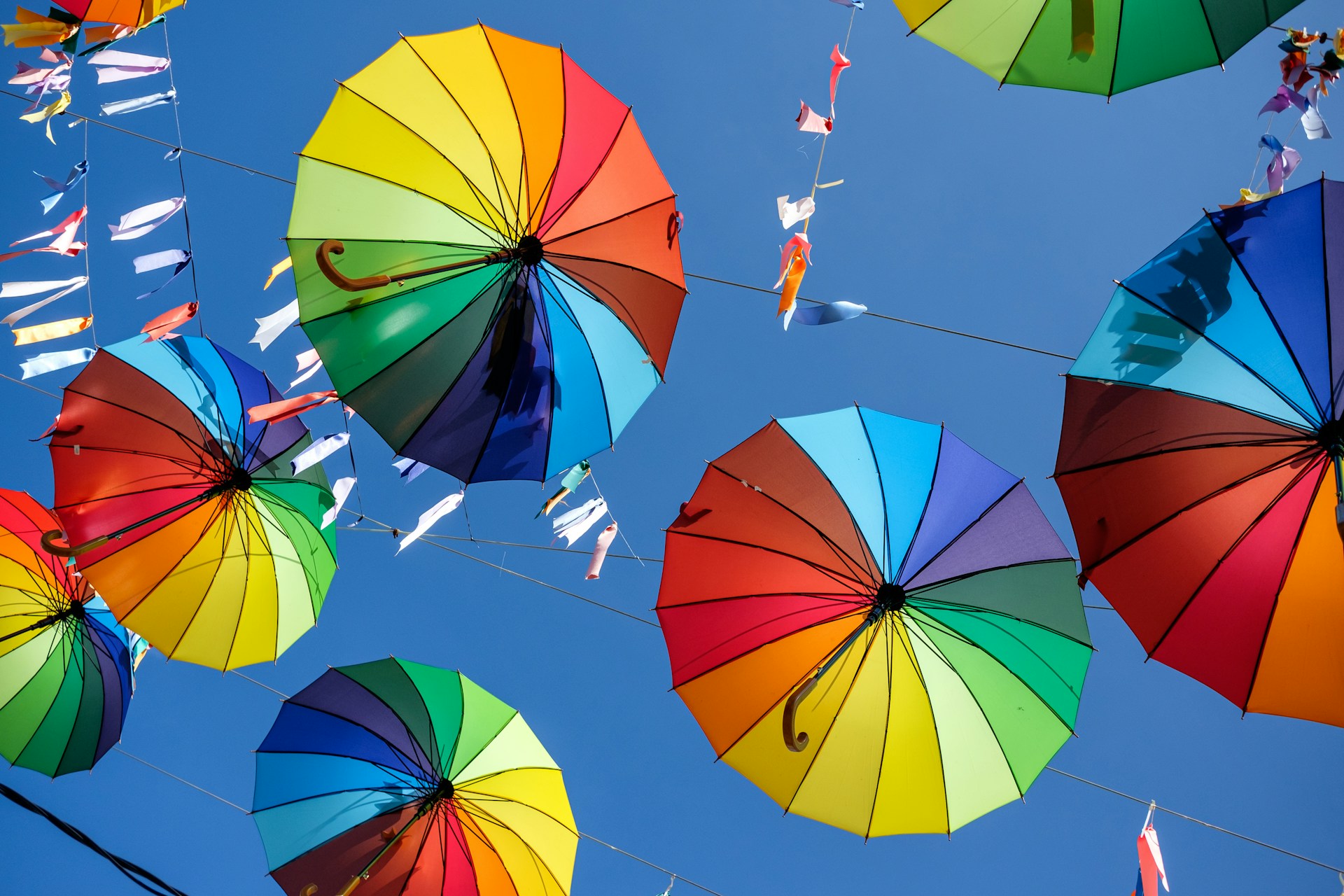 a group of colorful umbrellas hanging from a wire