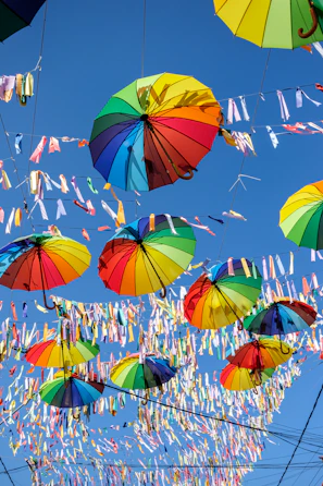 Colorful banners and umbul-umbul hanging outdoors in bright sunlight.