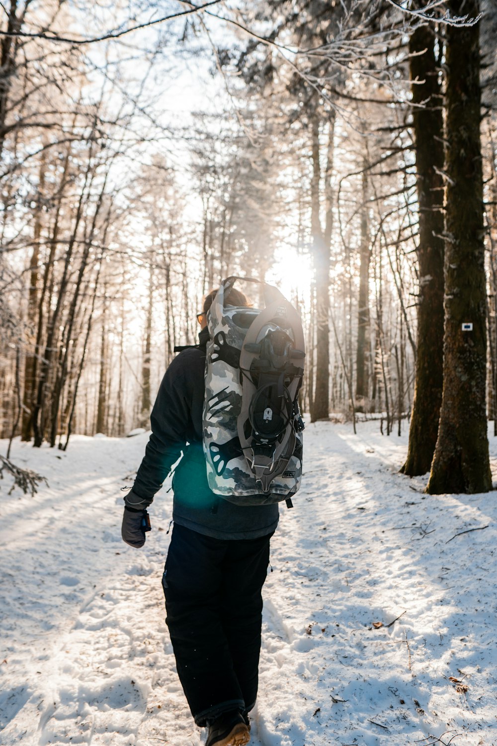 a person with a backpack walking in the snow