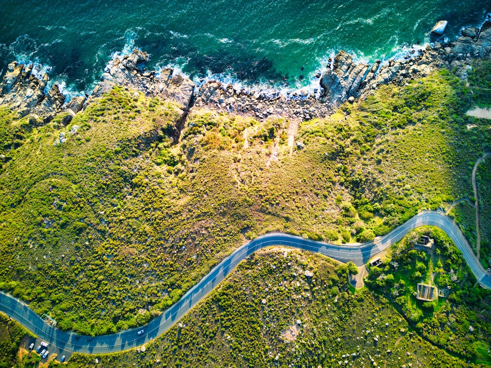 an aerial view of a winding road next to the ocean