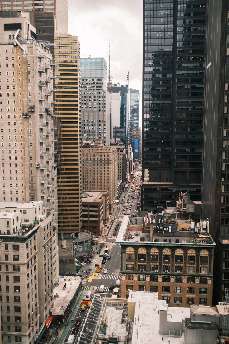 Tall skyscraper dominates the cityscape, reflecting glass facade amidst bustling urban streets below