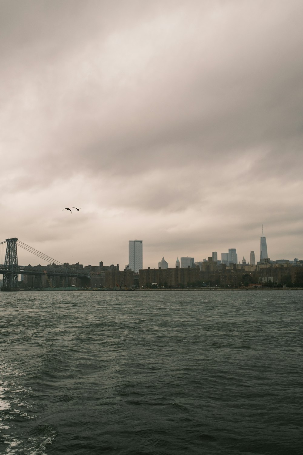 a large body of water with a bridge in the background