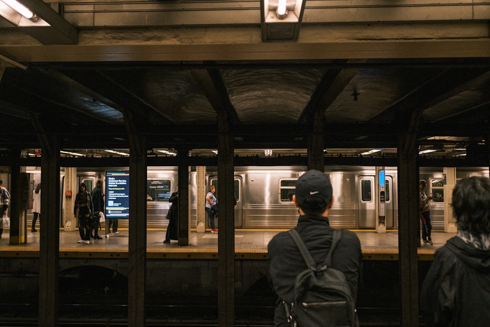 a group of people waiting for a train at a train station