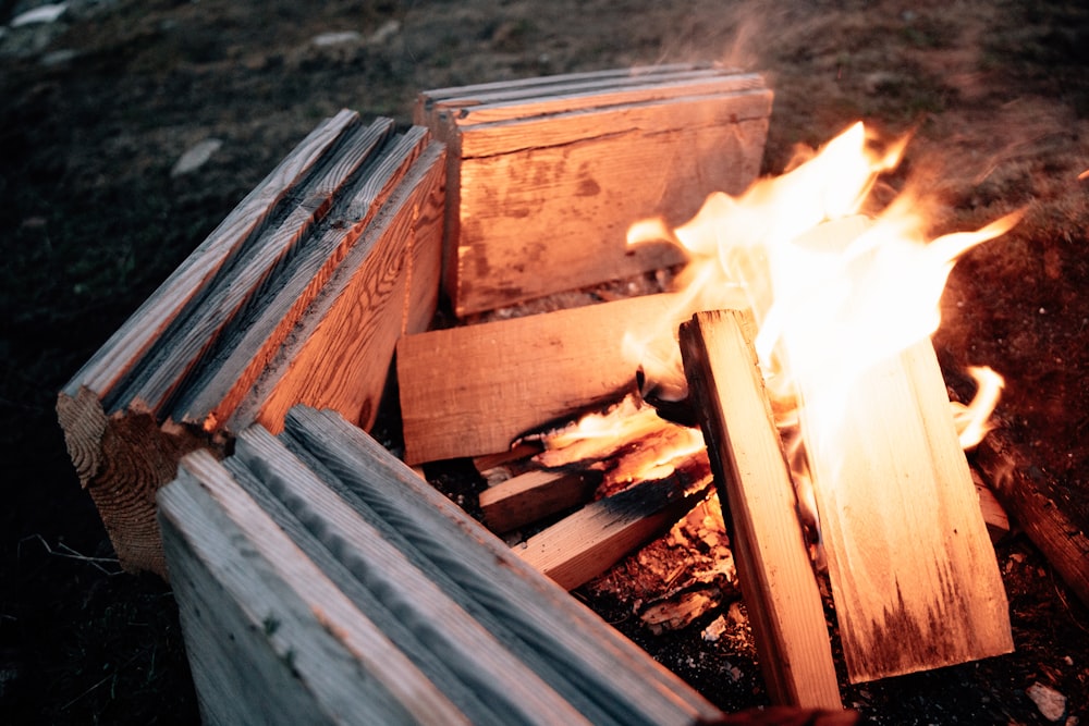 a fire burning in a wooden box on the ground