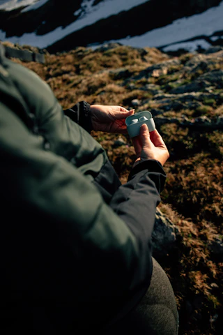 Close-up of a person wearing wireless earbuds while jogging outdoors on a sunny day.