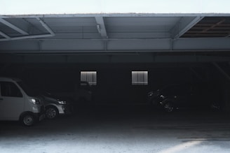 Dimly lit garage with eerie shadows and cobwebs hanging from the ceiling.