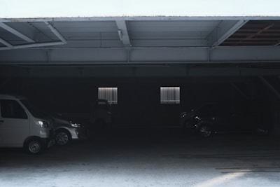 Dimly lit garage with eerie shadows and cobwebs hanging from the ceiling.