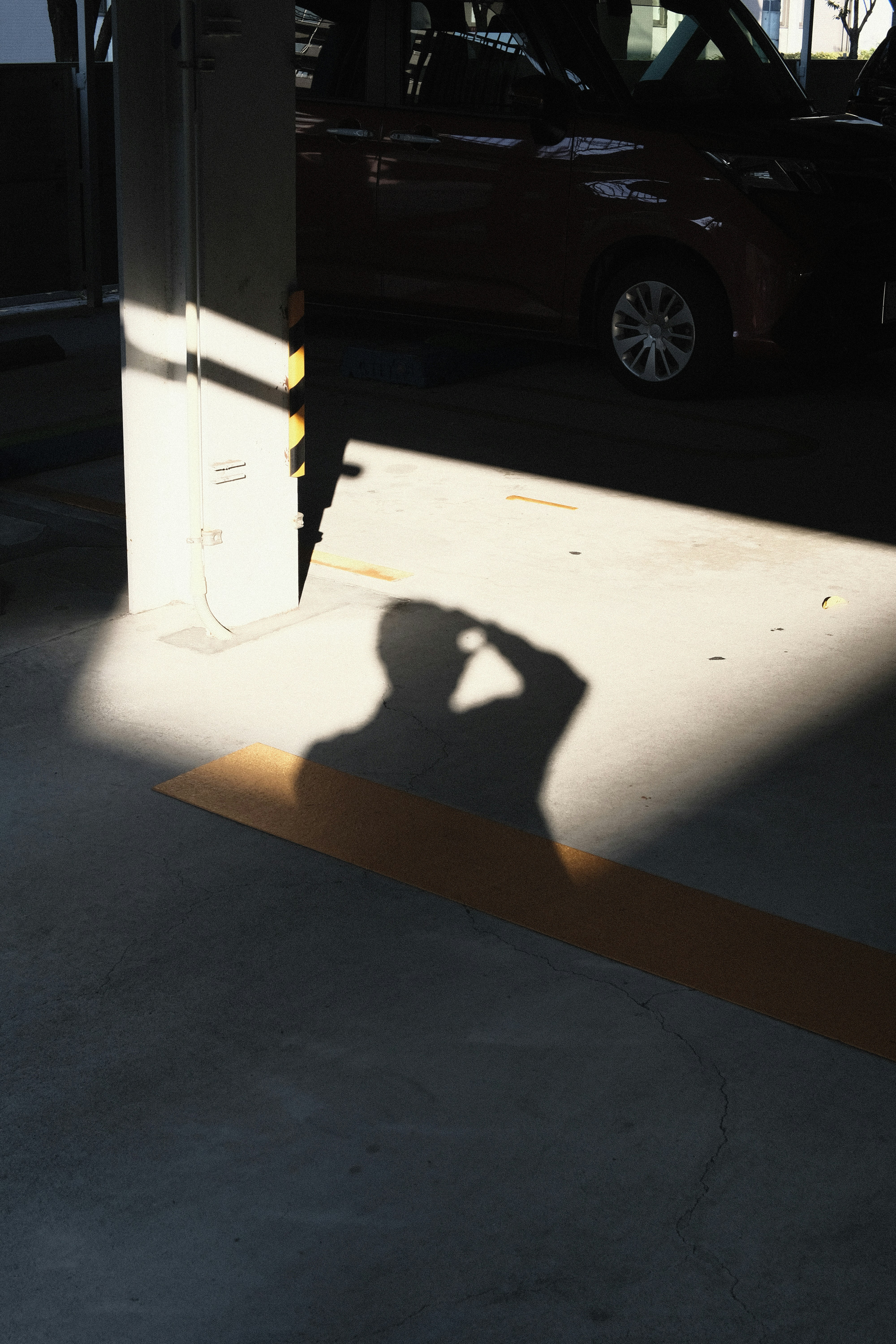 a shadow of a person taking a picture with a cell phone