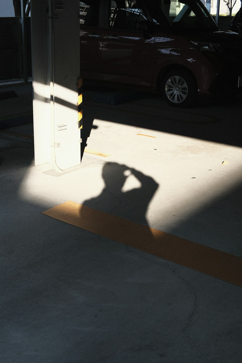 a shadow of a person taking a picture with a cell phone