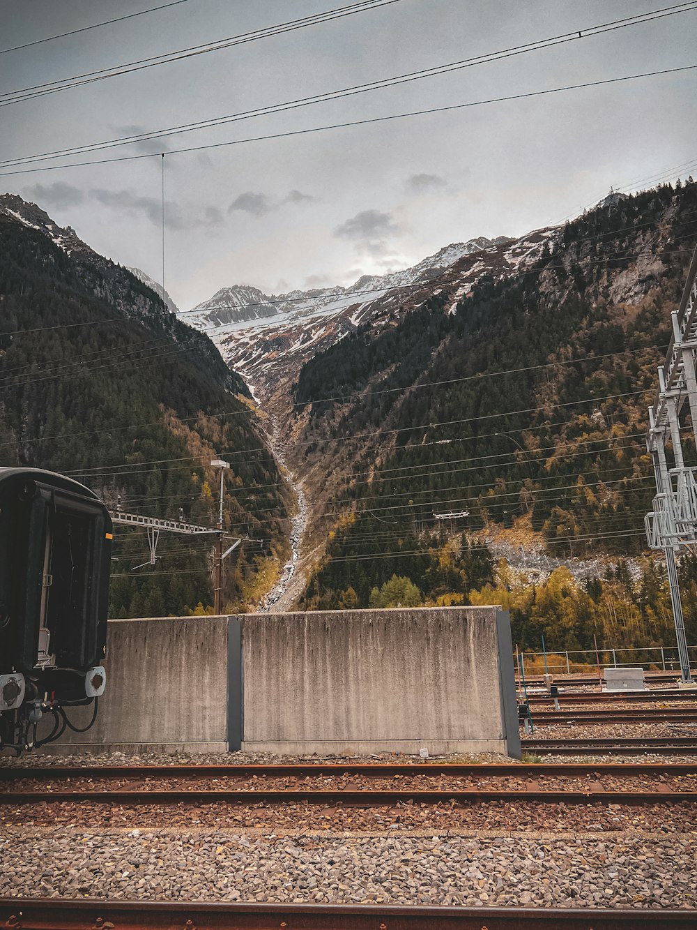 a train traveling down train tracks next to a mountain