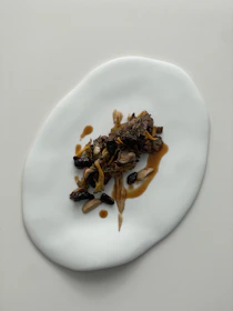 A close-up of a minimalist Japanese-inspired dish served on a sleek red plate.