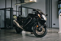 A sleek modern motorcycle tire displayed on a stylish black metal shelf with red accent lighting.
