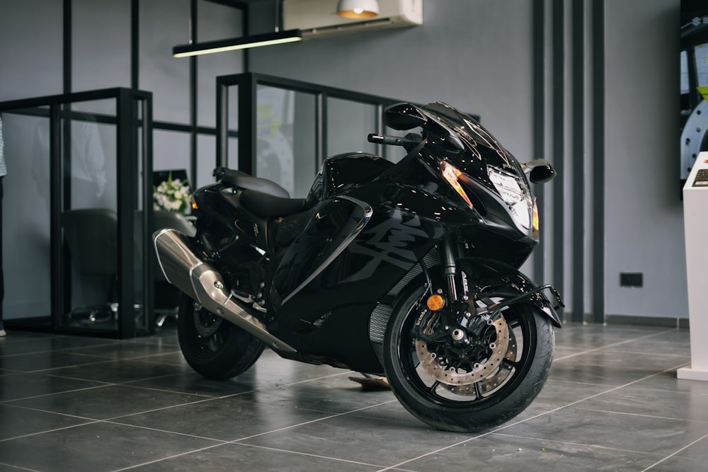 a black motorcycle parked inside of a building