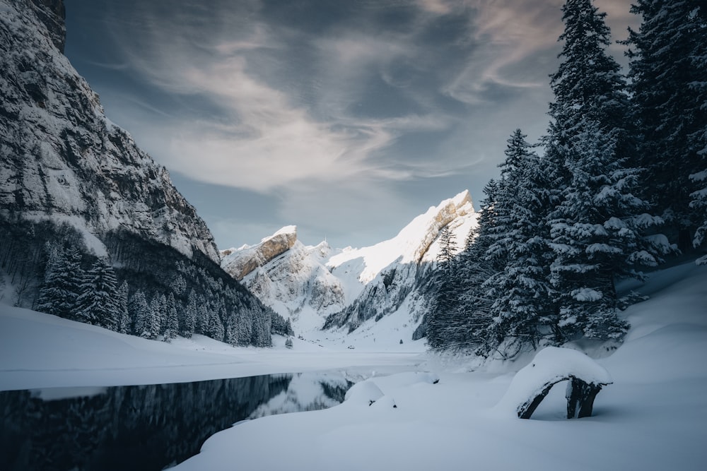 a snow covered mountain with a lake in the foreground