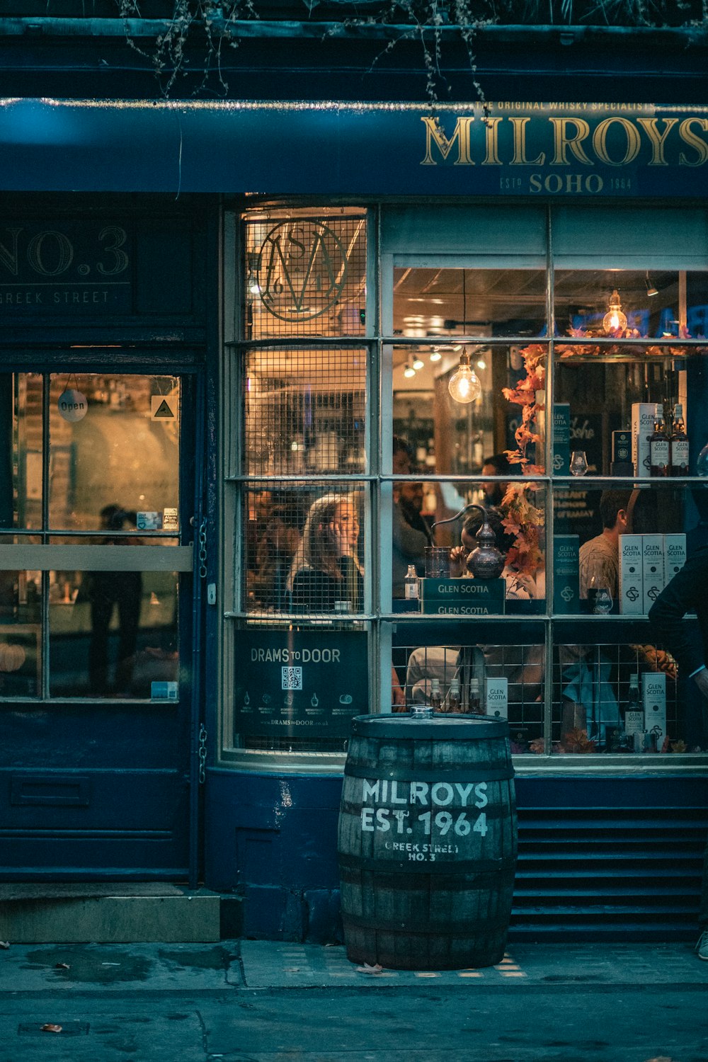 a man walking past a store front with an umbrella