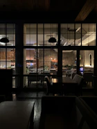 A cozy Scandinavian-style restaurant interior with warm lighting and a team member planning social media content on a laptop.