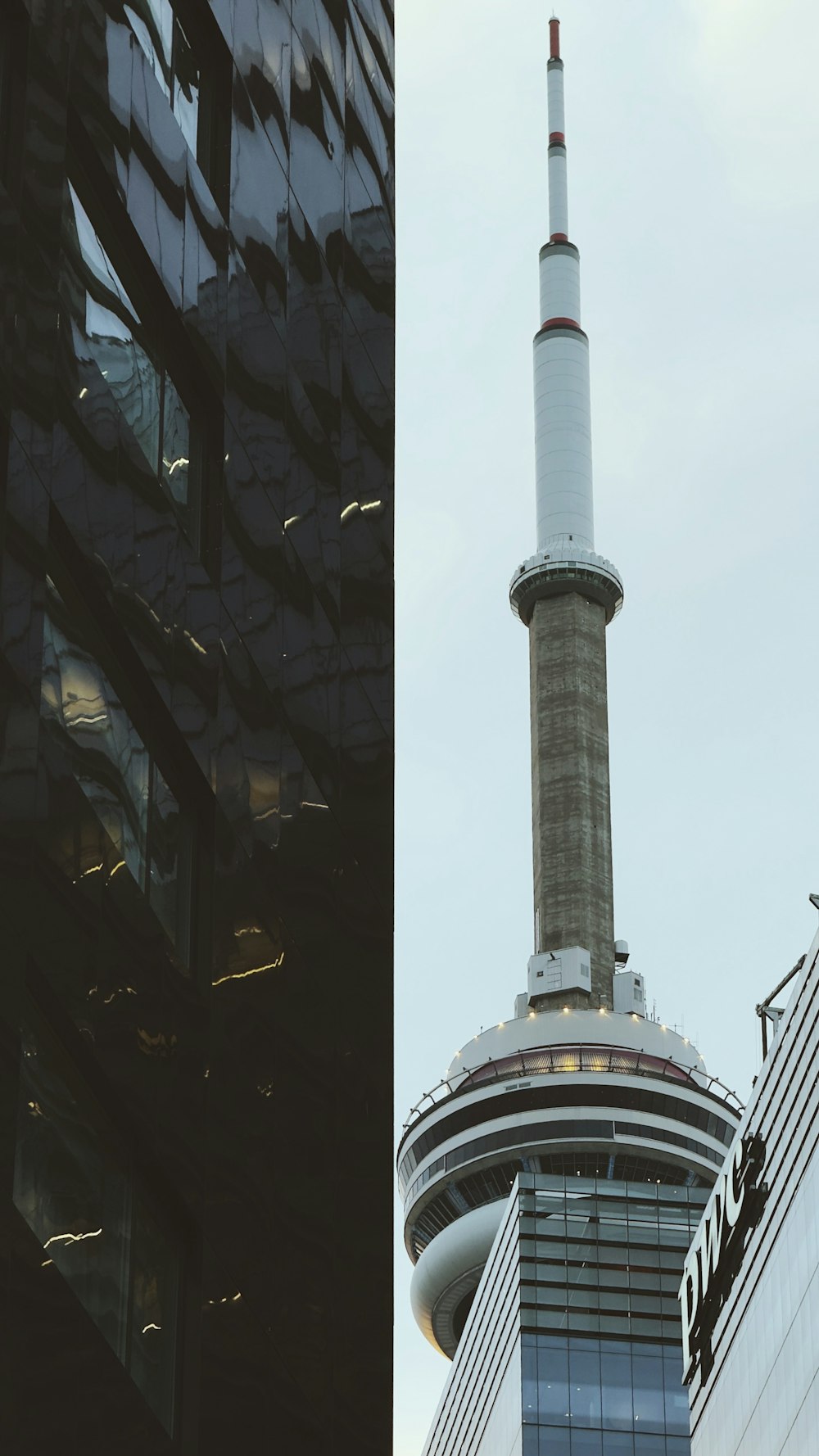 a tall building next to a tall building with a sky scraper on top