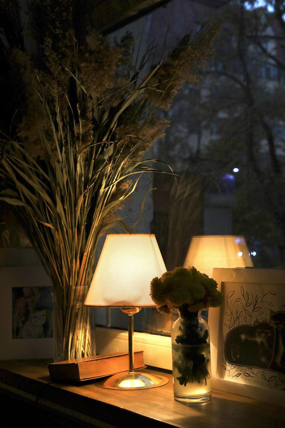 a table with a vase of flowers and a lamp on it