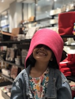 A cheerful child trying on a playful outfit from the kids' clothing section.