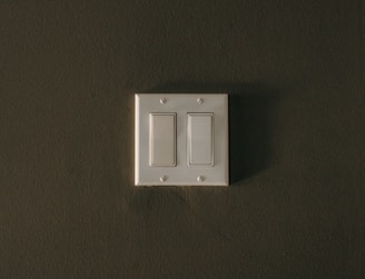 a white light switch sitting on top of a wall