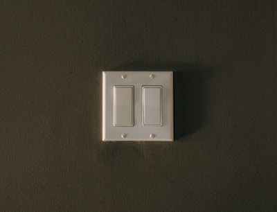 a white light switch sitting on top of a wall