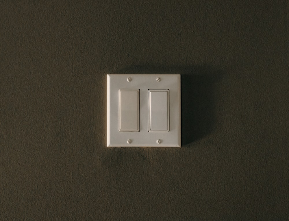 a white light switch sitting on top of a wall