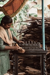 a woman standing over a table with a cat on top of it