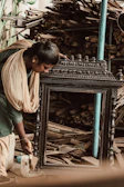 Artisan applying fine finishing touches to a traditional Rajasthani wooden photo frame.