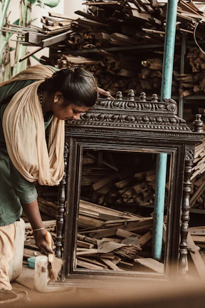 Artisan applying fine finishing touches to a traditional Rajasthani wooden photo frame.