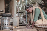 A dedicated Brazilian woman packaging her handmade products with care in a bright workspace.