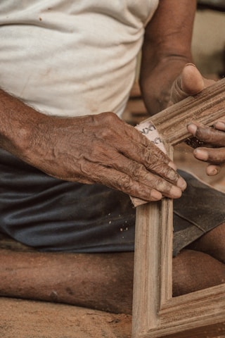 Close-up of hands smoothing drywall seams with professional tools.