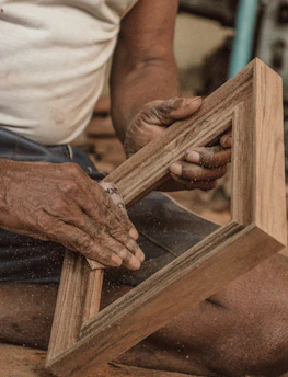 Close-up of hands crafting wooden furniture in a workshop.