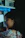 A thoughtful young woman reading a blog on a dark-themed laptop in a cozy room with neon blue lighting.