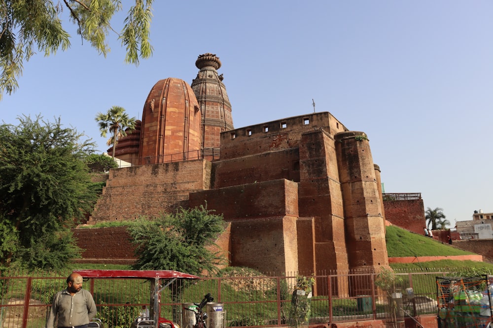 a man standing in front of a large brick building