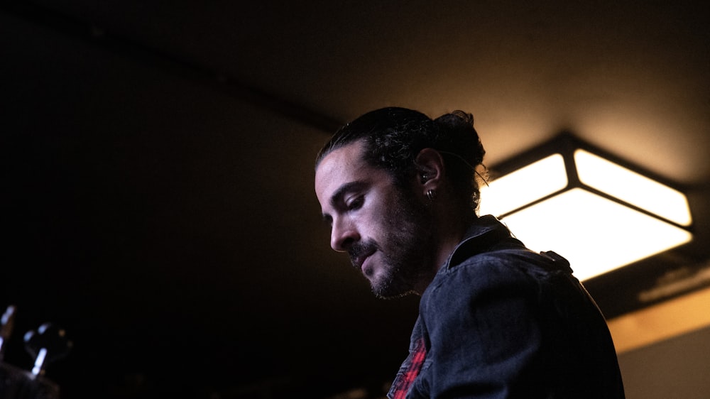 a man in a dark room looking at his cell phone