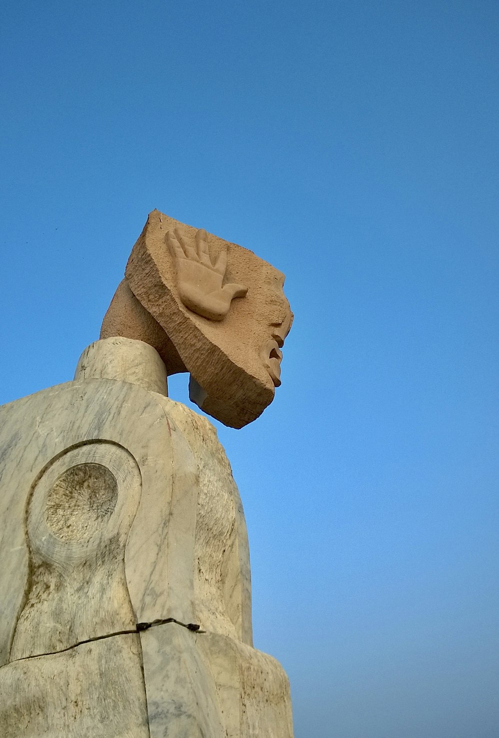 a statue of a head on top of a rock