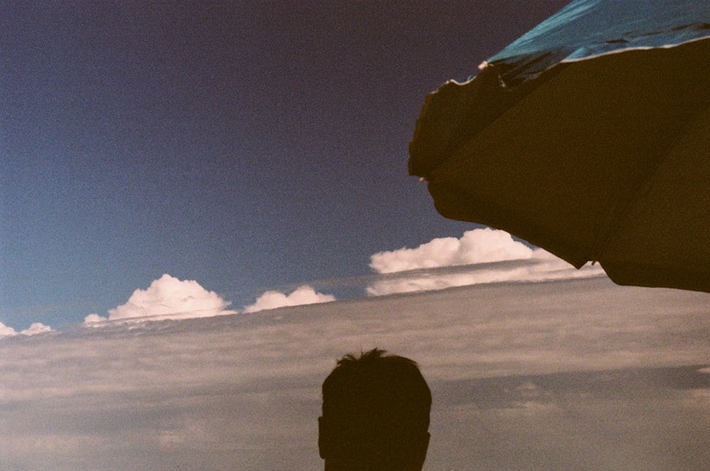 a silhouette of a man holding an umbrella