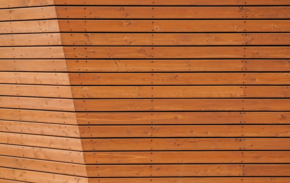 a close up of a wooden wall with a bench in front of it