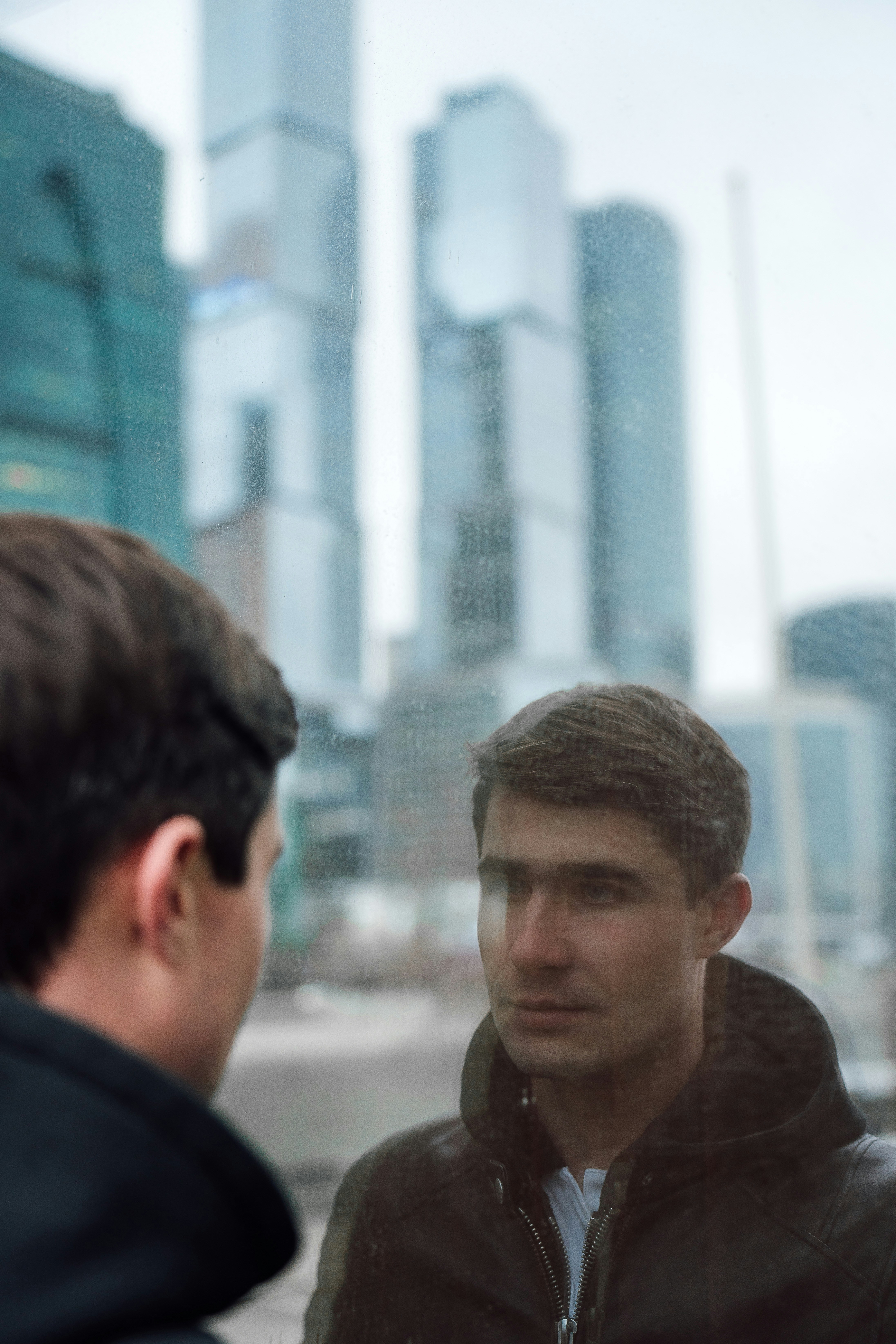 a man in a black jacket looking at another man in a black jacket