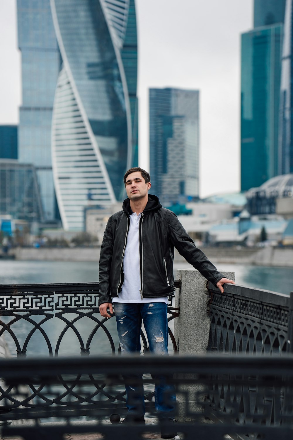 a man standing on a bridge in front of a city